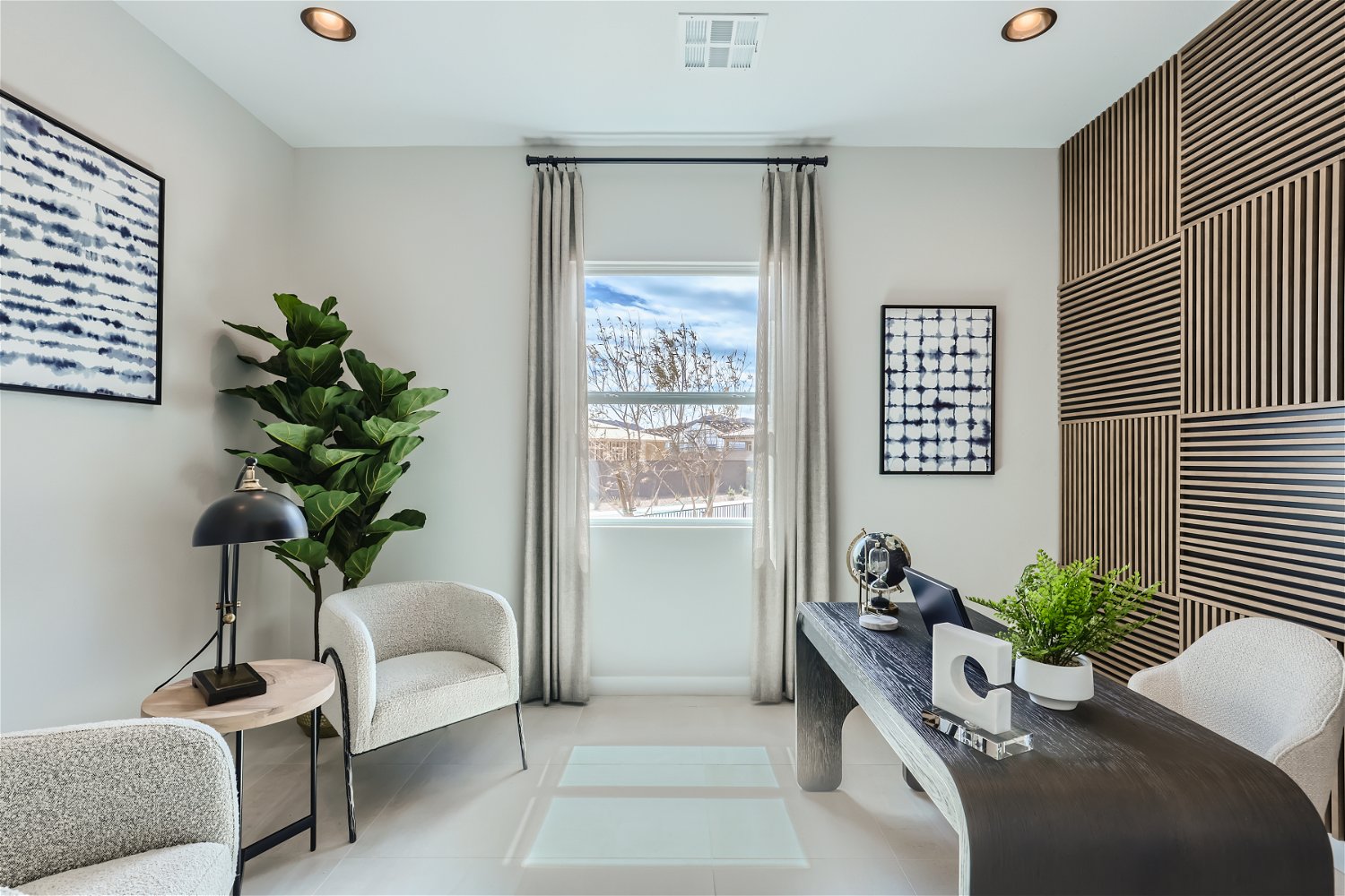 A room with a couch and a table with a plant in it.