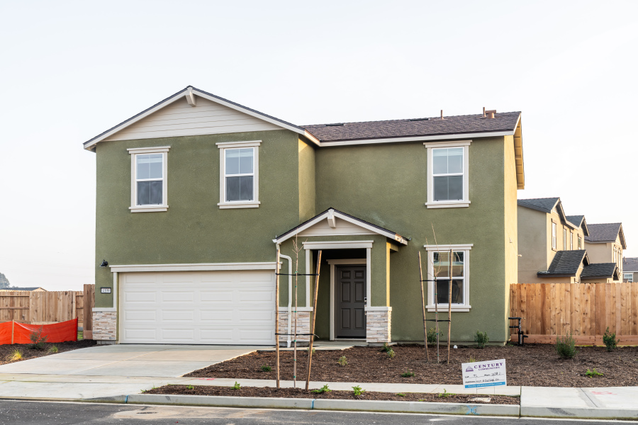 A green house with a garage.