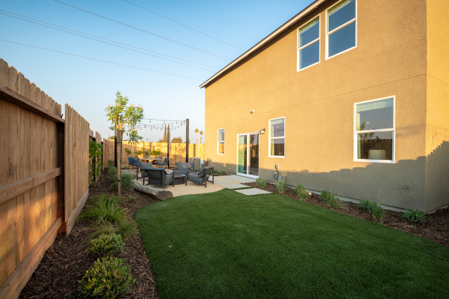 A backyard with a fence and a lawn.