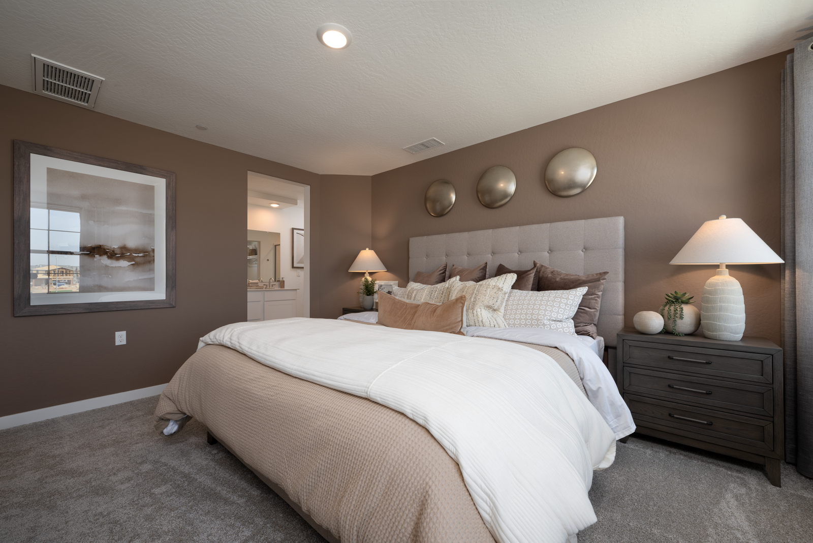 A bedroom with a bed and lamps.