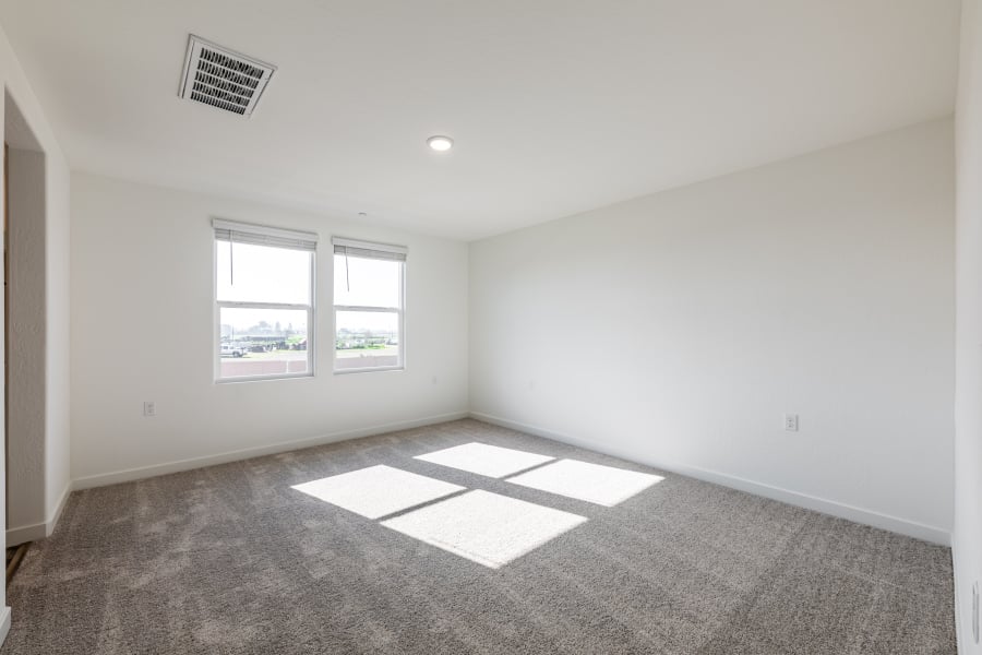 A room with a rug and windows.