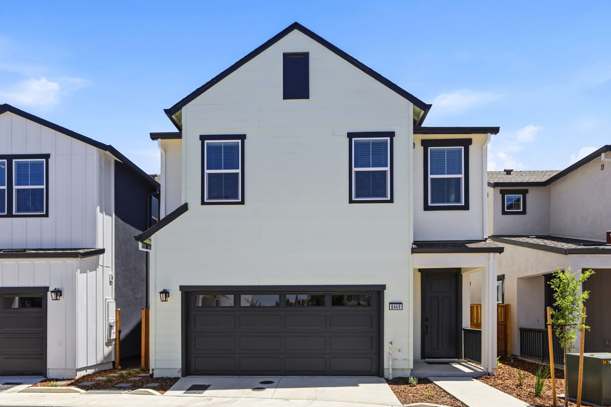 A white house with garages.