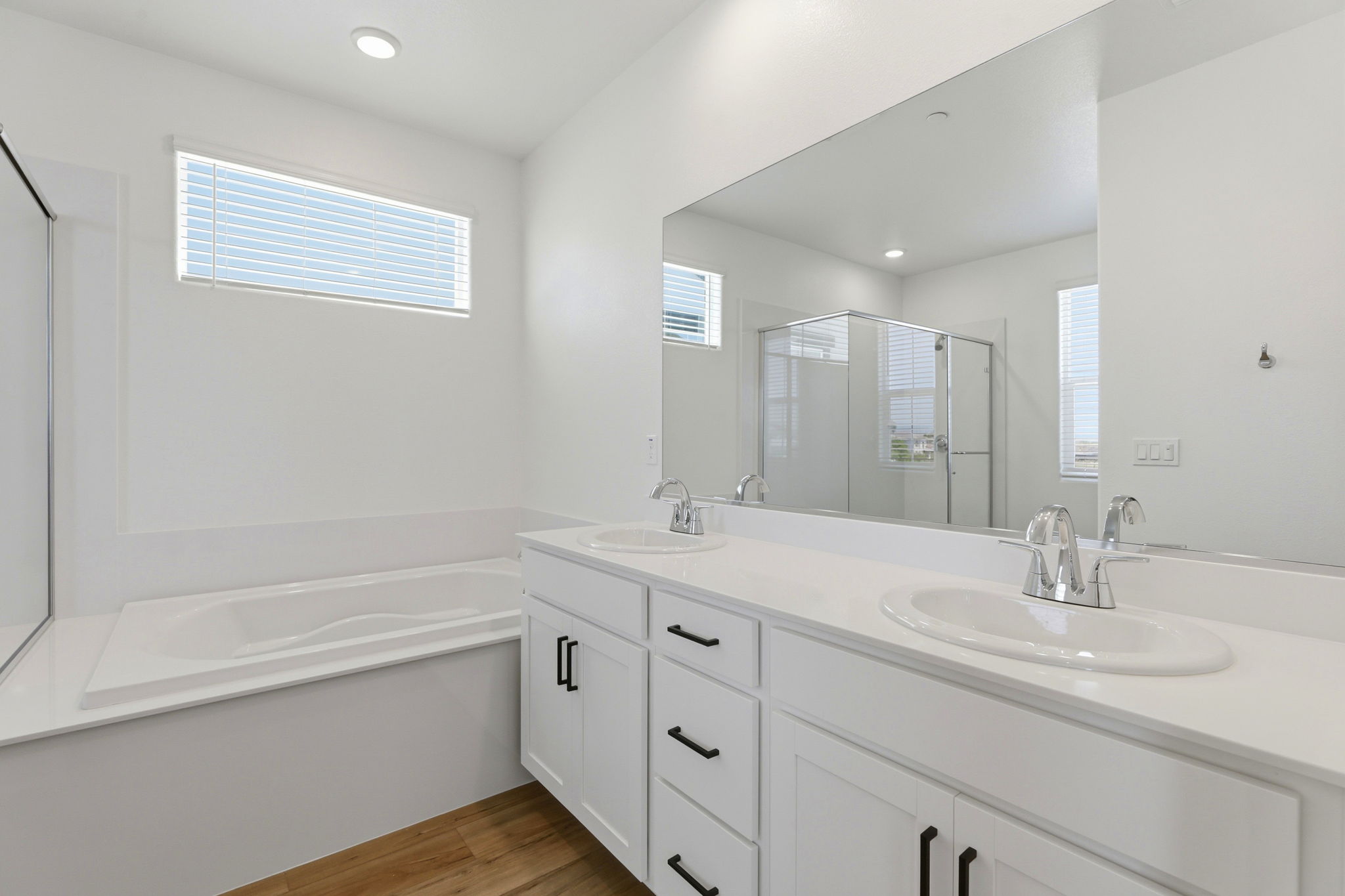 A bathroom with a tub sink and mirror.