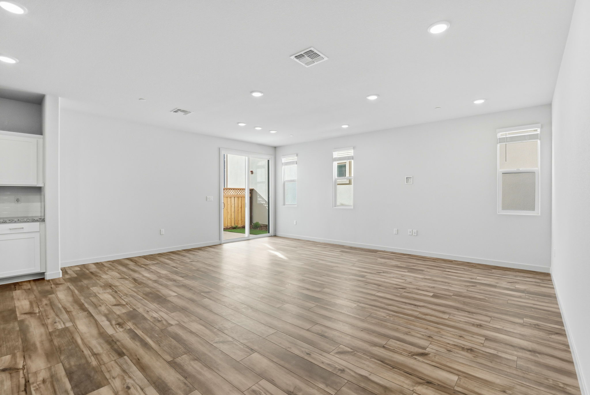 A room with a wood floor and white walls.