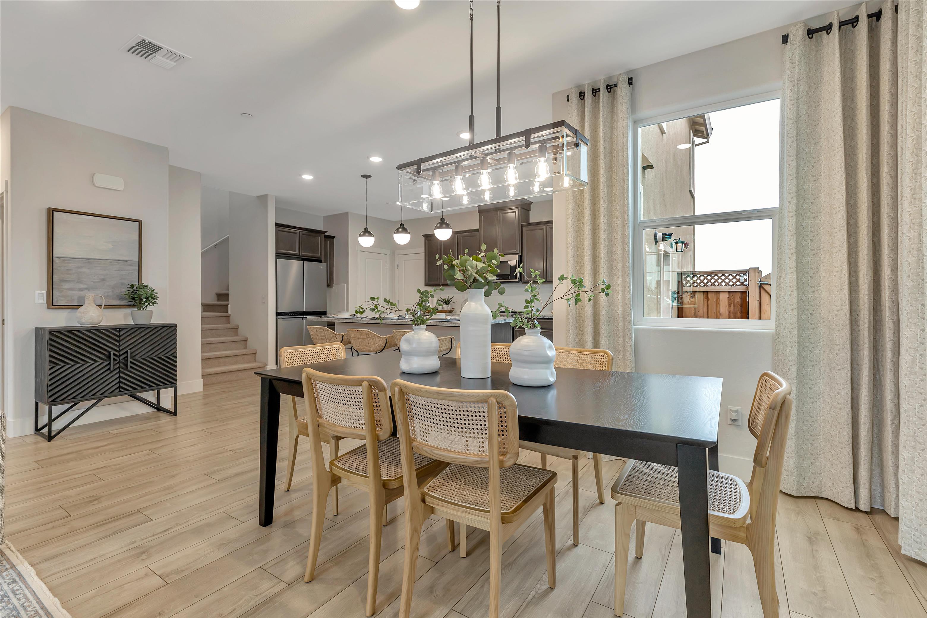 A dining room with a chandelier and a table with chairs.
