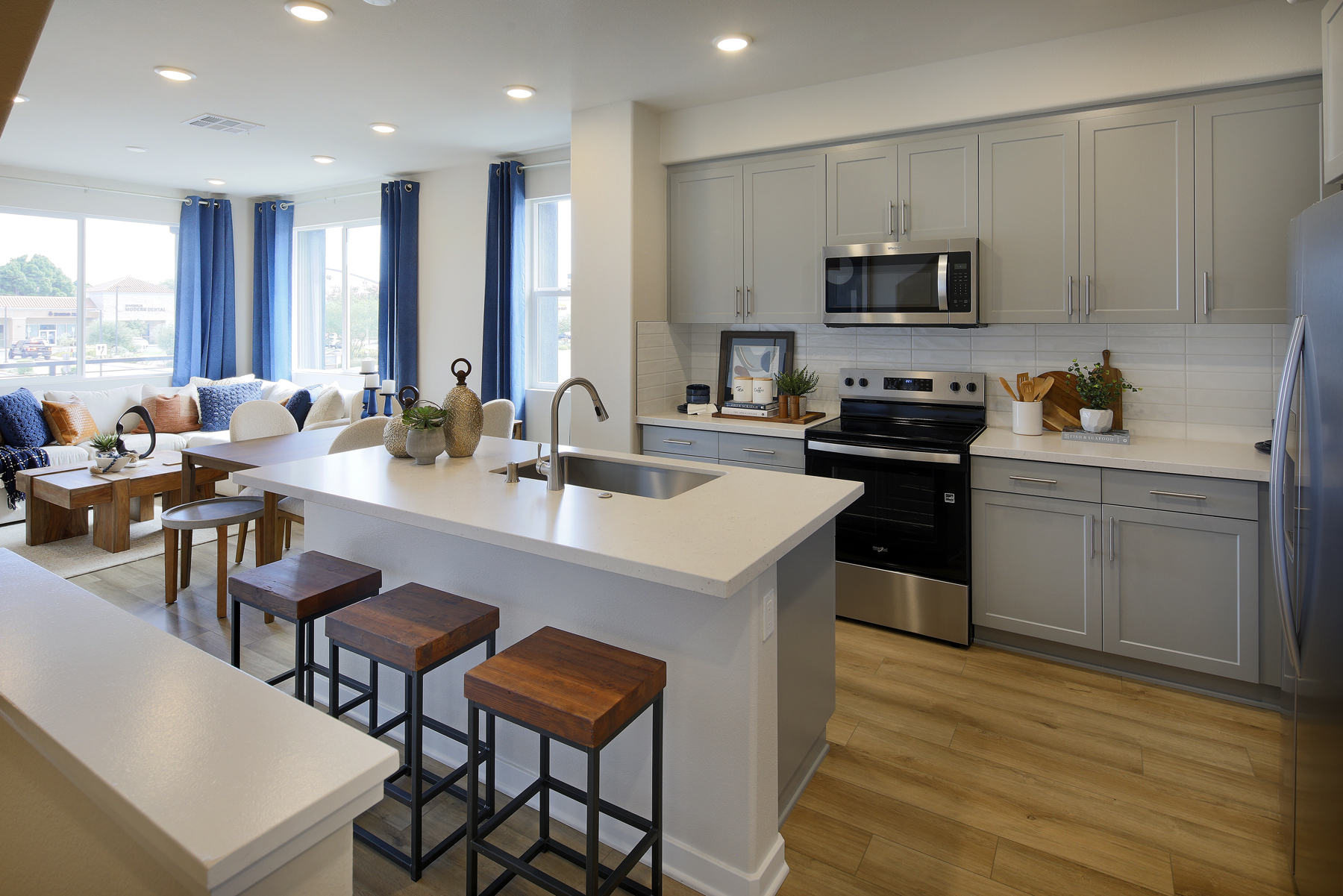 A kitchen with a bar stools.