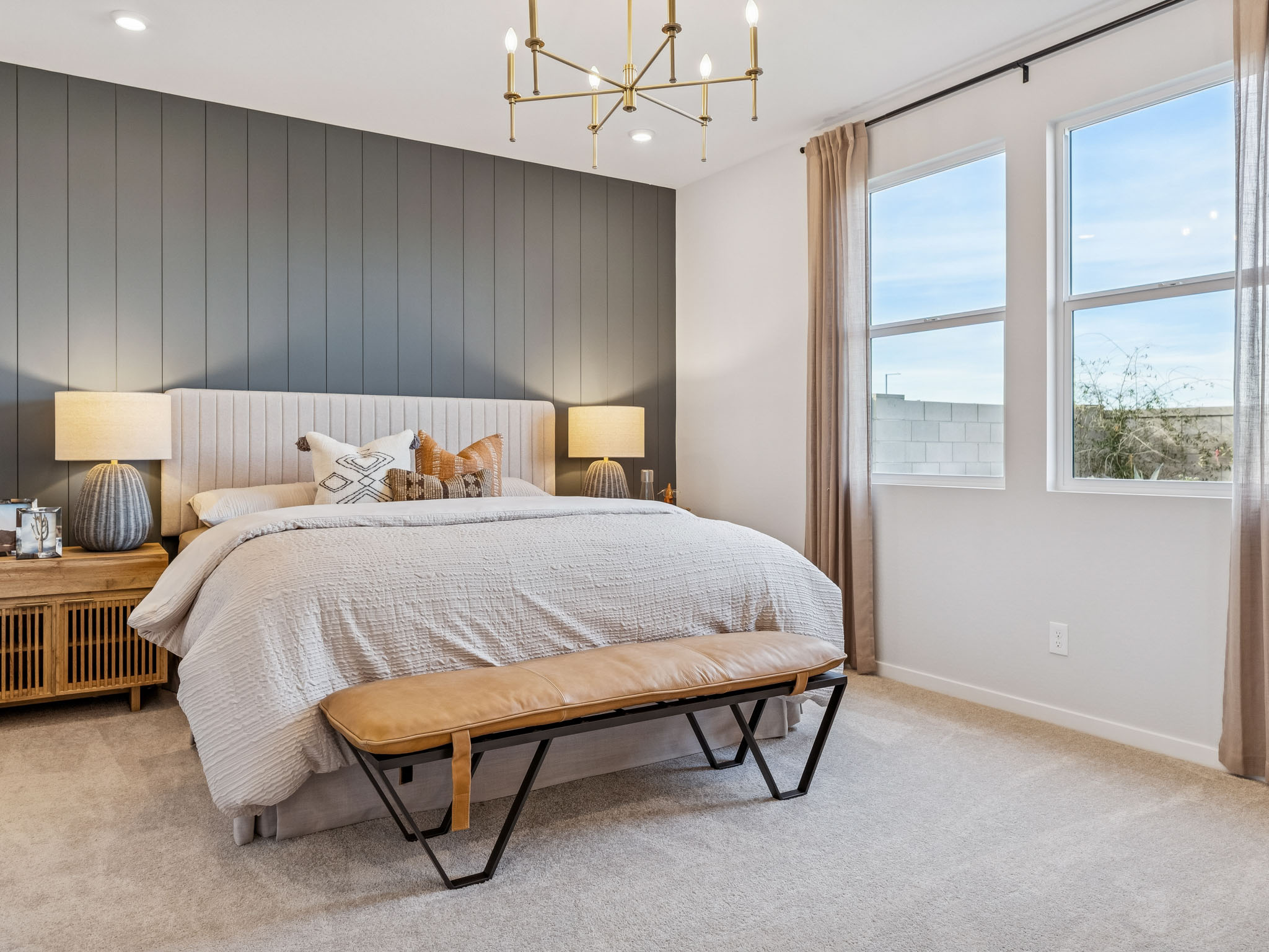 A bedroom with a bed and a bench.