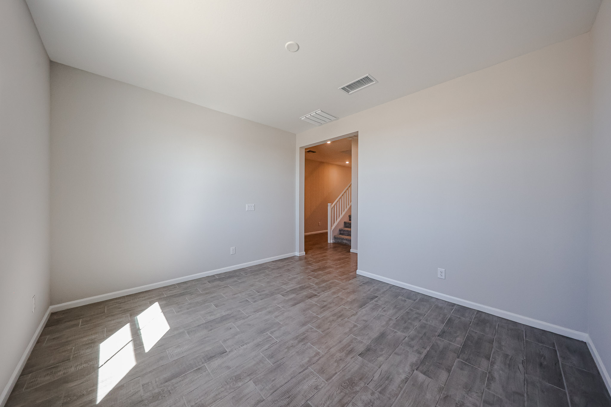 A hallway with a wood floor.