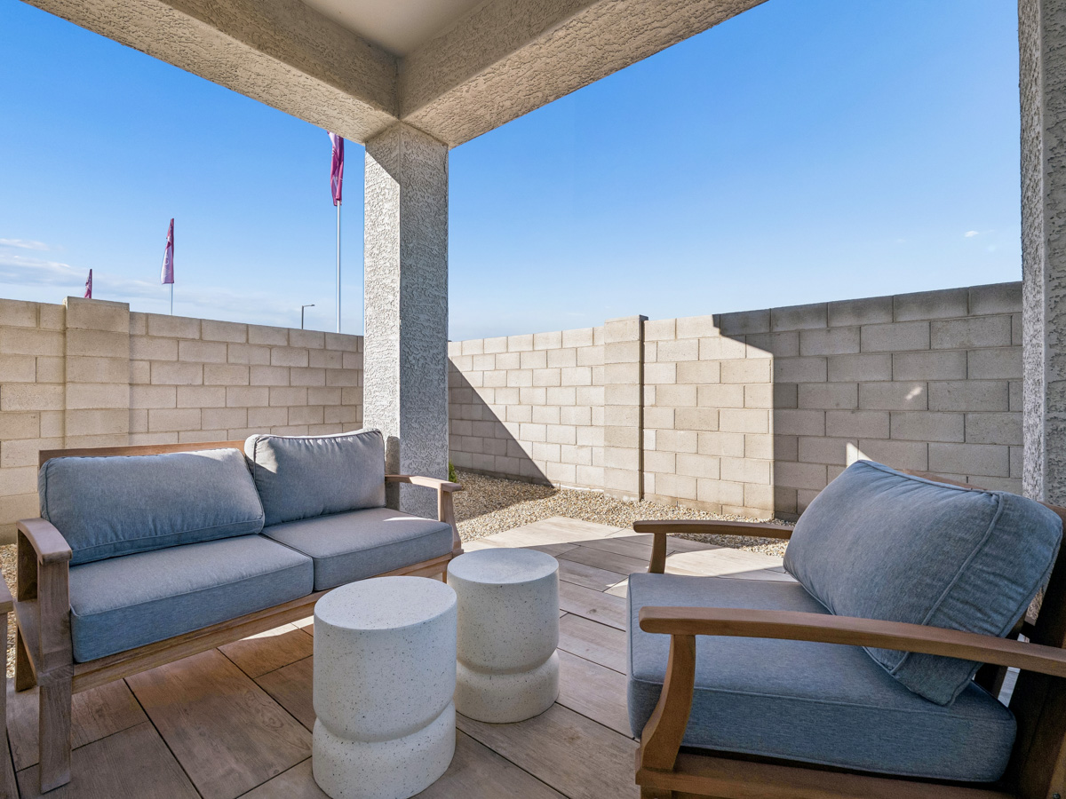 A couch and a chair in a room with a stone wall.