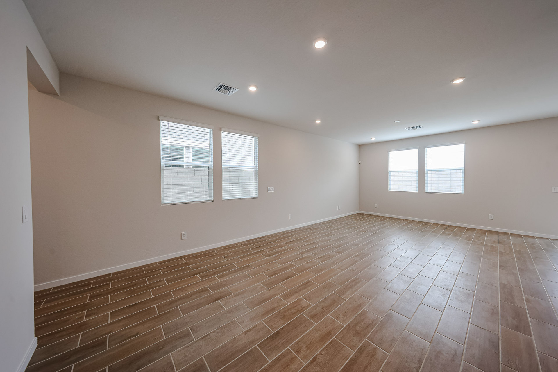 A room with a wood floor and windows.