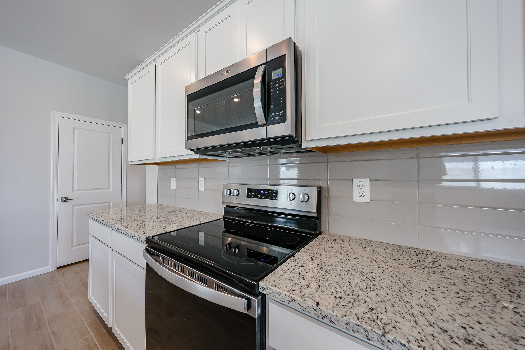 A kitchen with white cabinets.