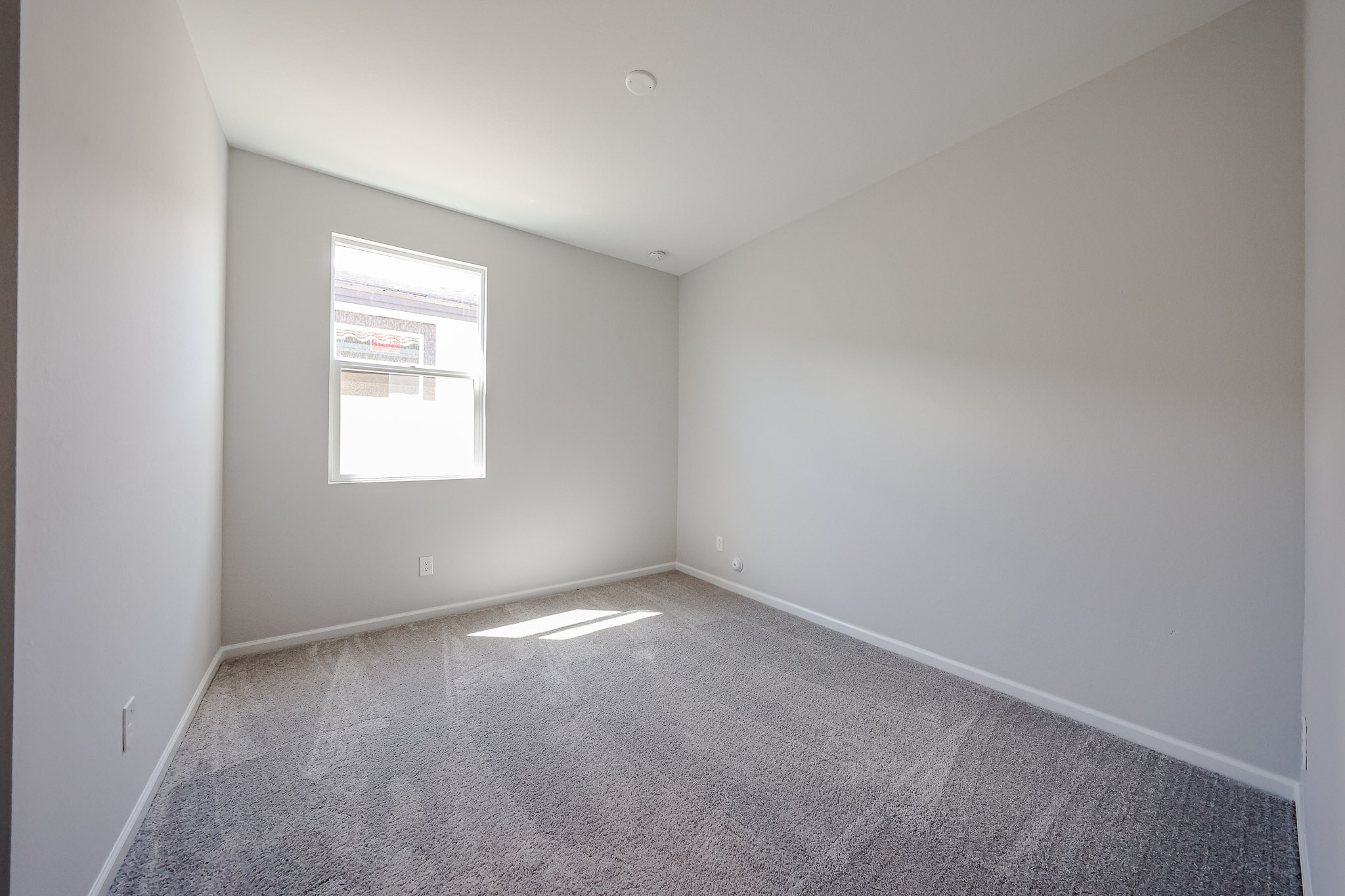 A room with a carpet and a window.