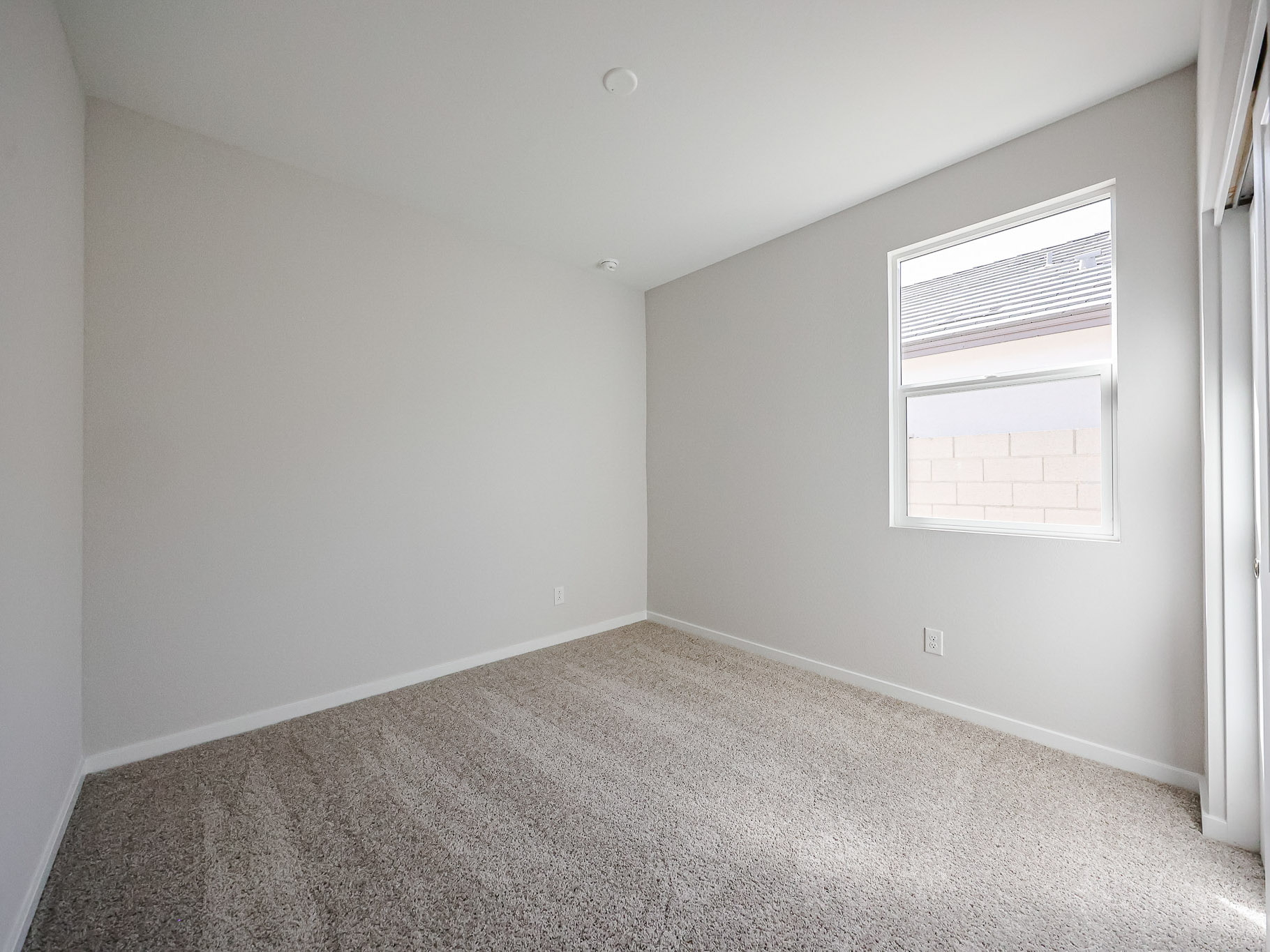 A room with a carpet and a window.