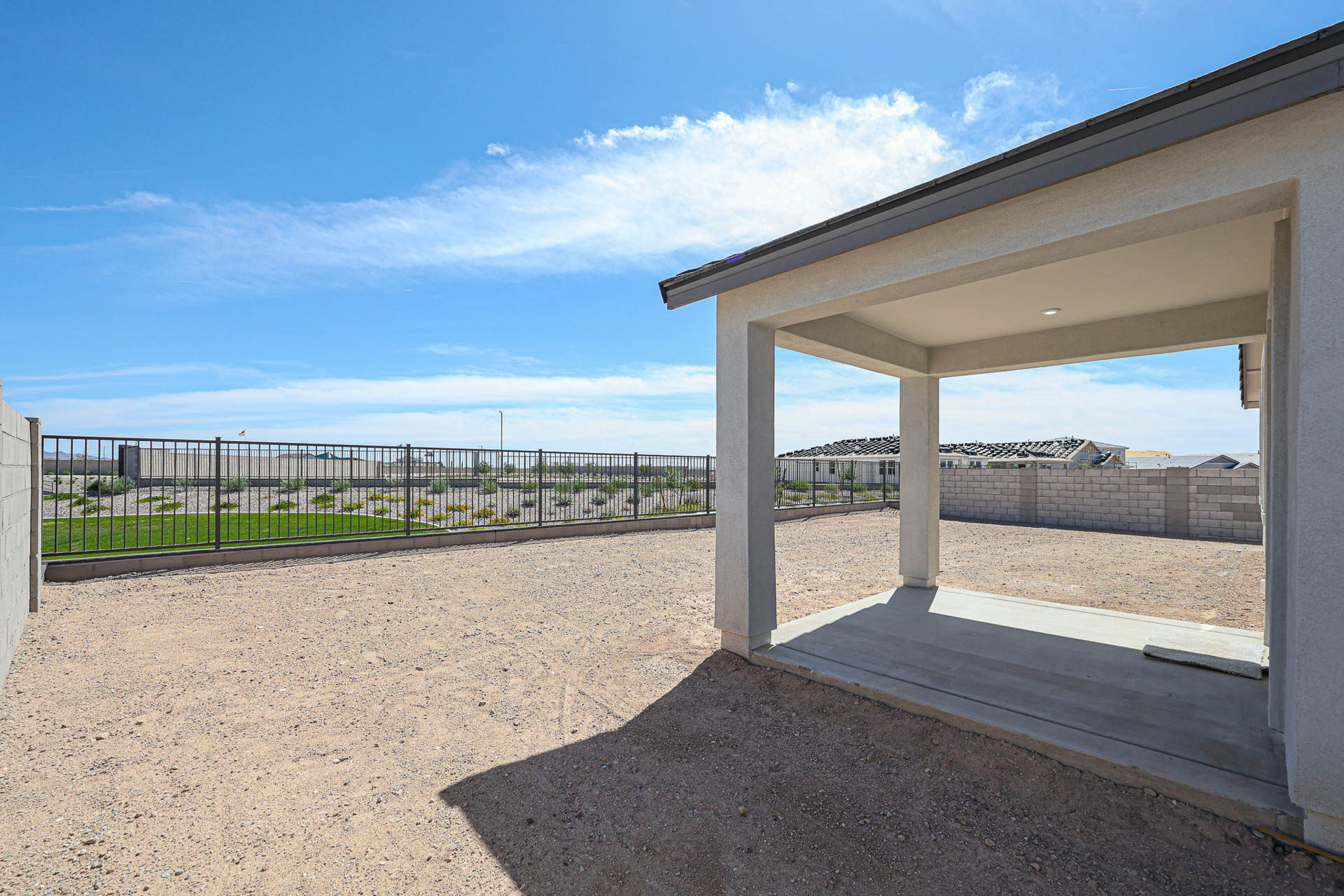 A building with a fence and a beach in the background.