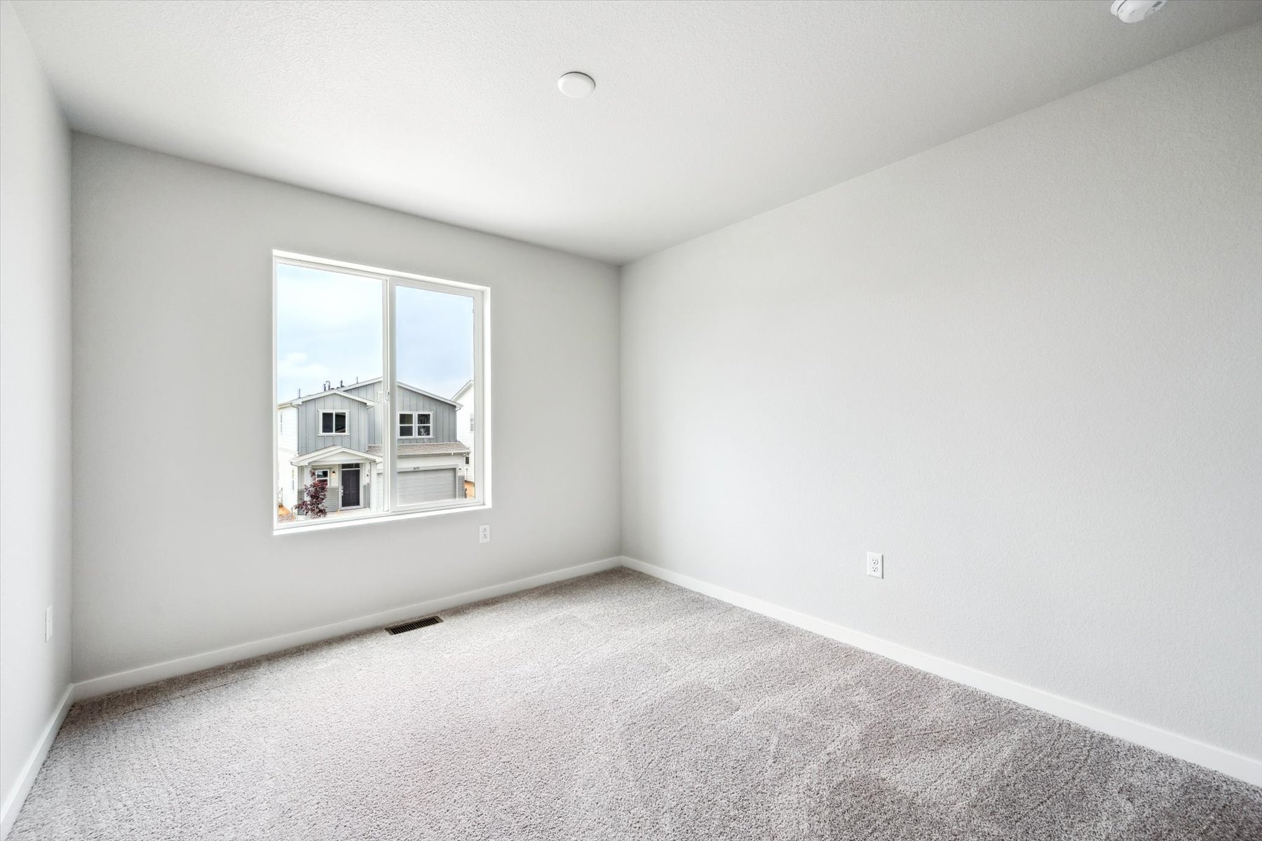 A room with a window and a carpet.