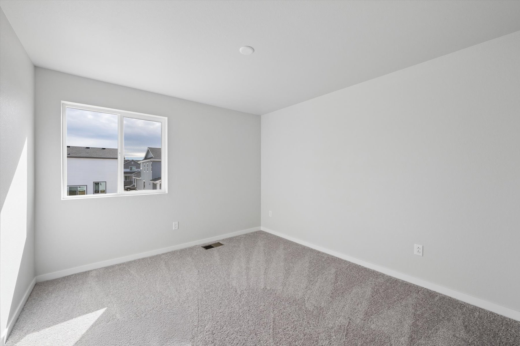 A room with a window and a carpet.