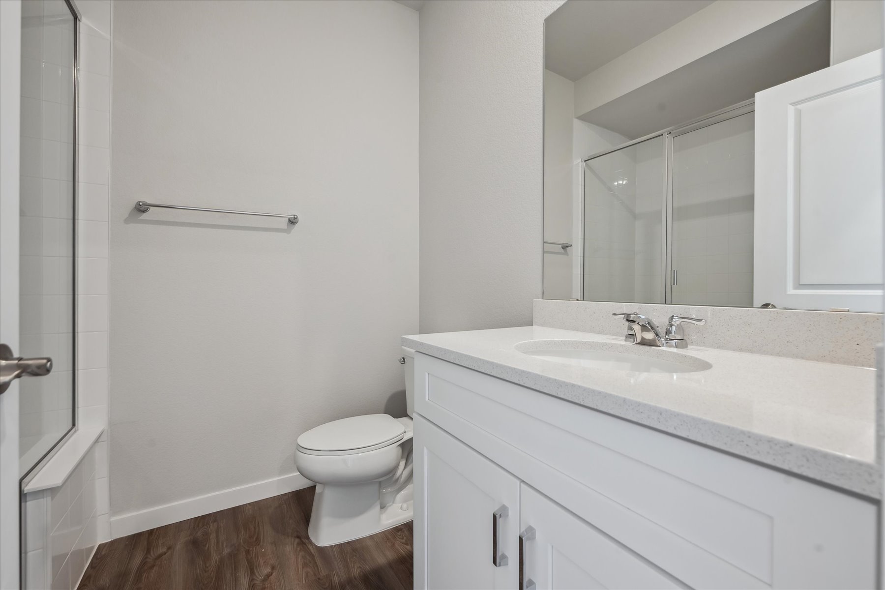 A bathroom with a sink toilet and mirror.