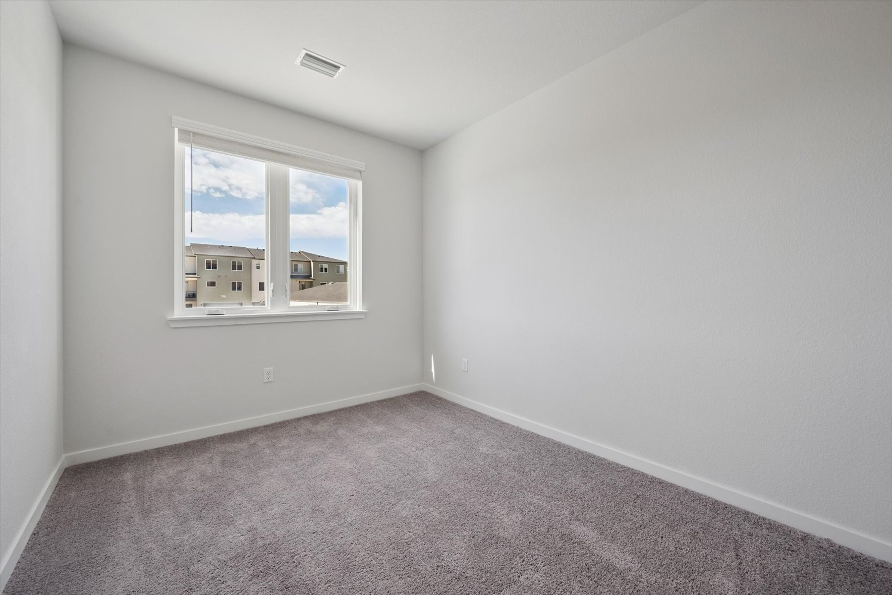 A room with a window and a carpet.