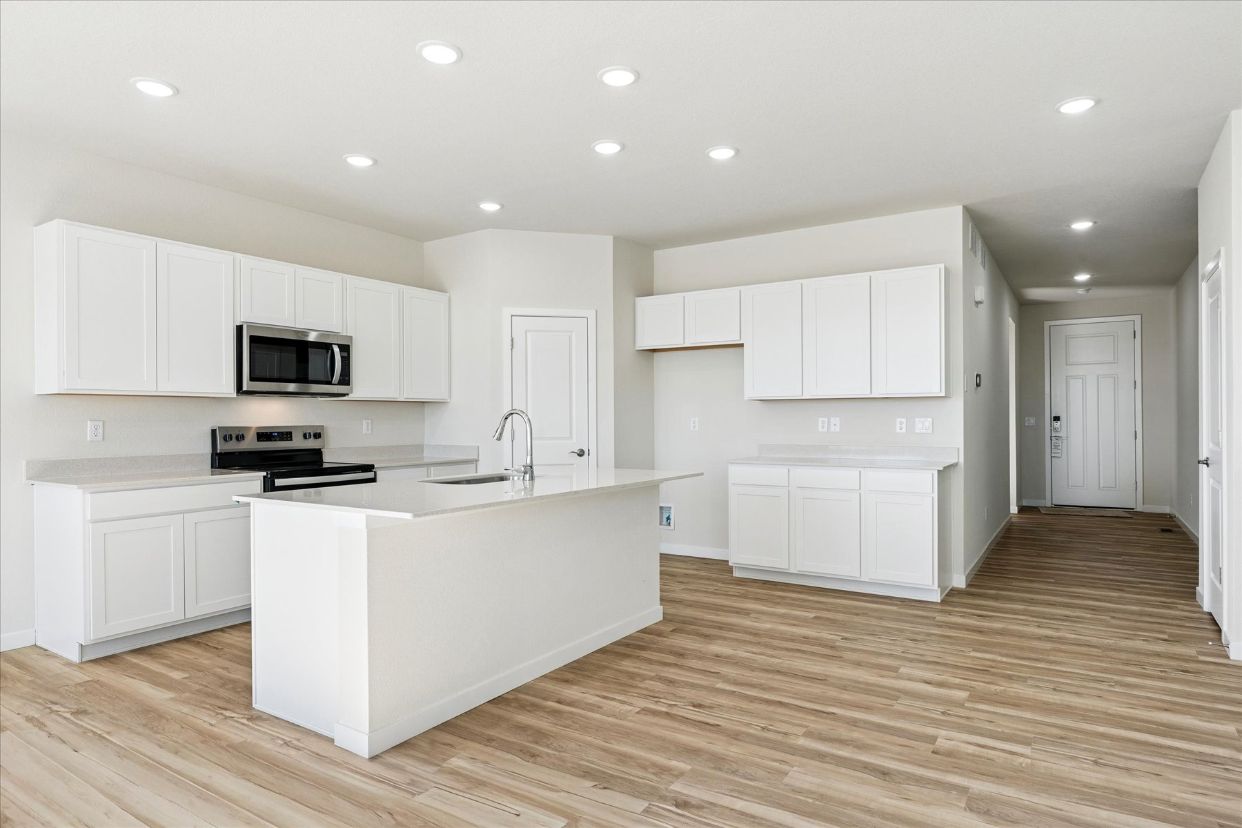 A kitchen with white cabinets.