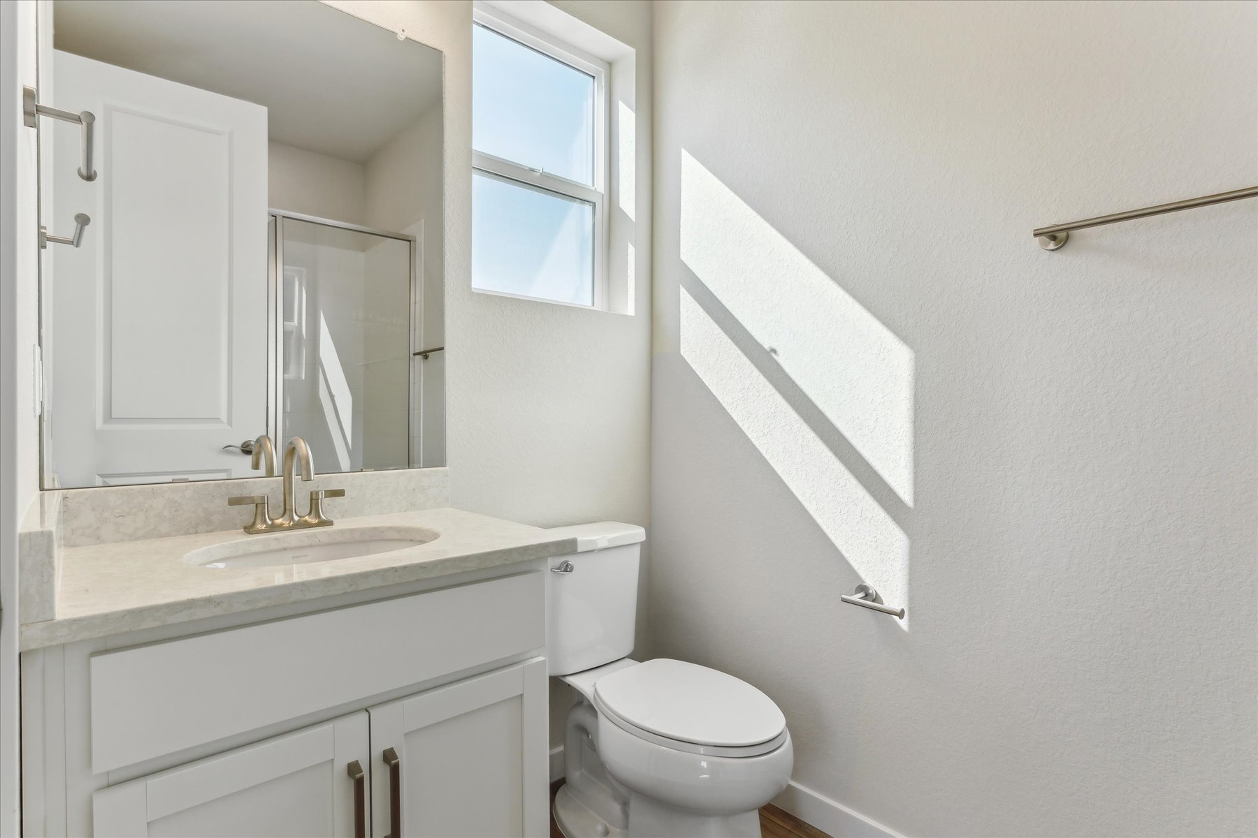 A bathroom with a sink toilet and mirror.