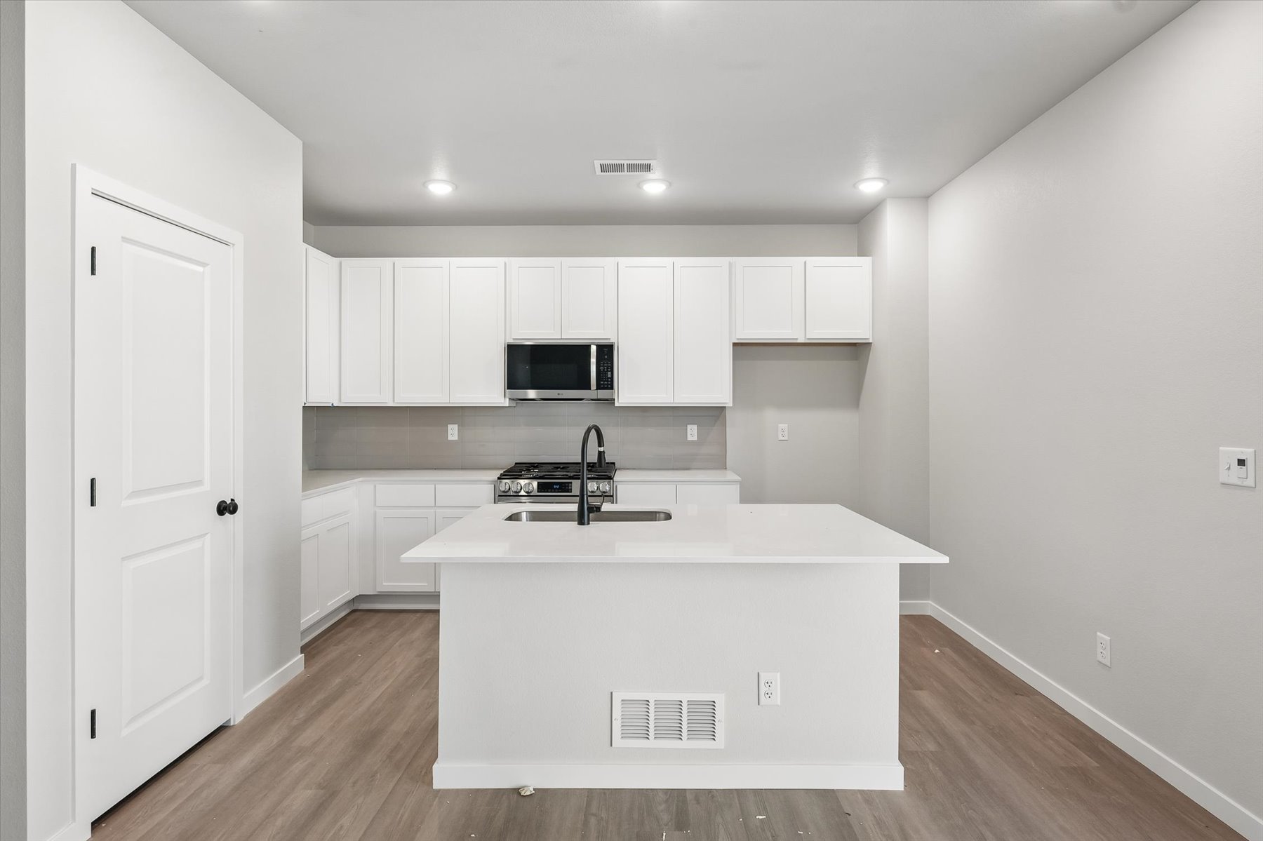 A kitchen with white cabinets.