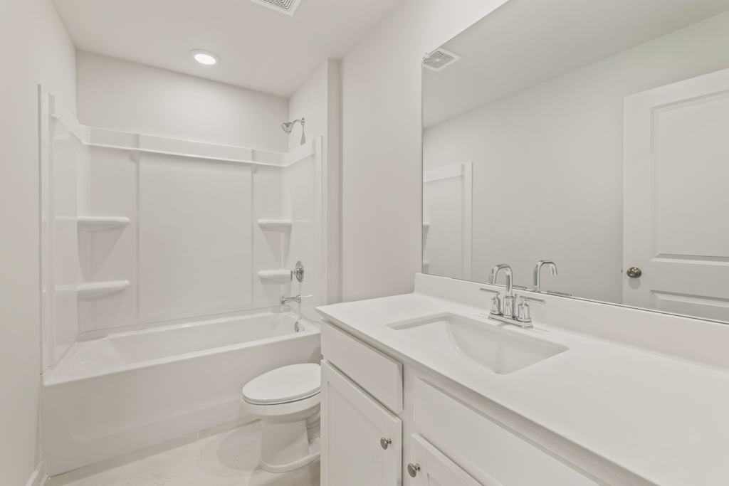 A bathroom with a tub sink and toilet.