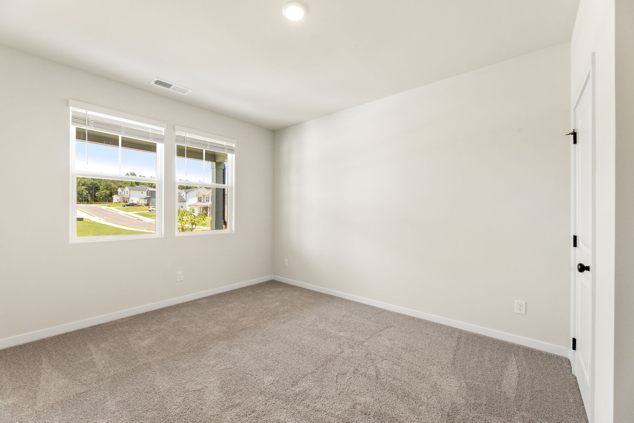 A room with a carpet and a window.