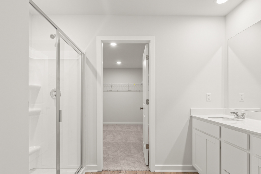 A bathroom with a shower unit and sink.