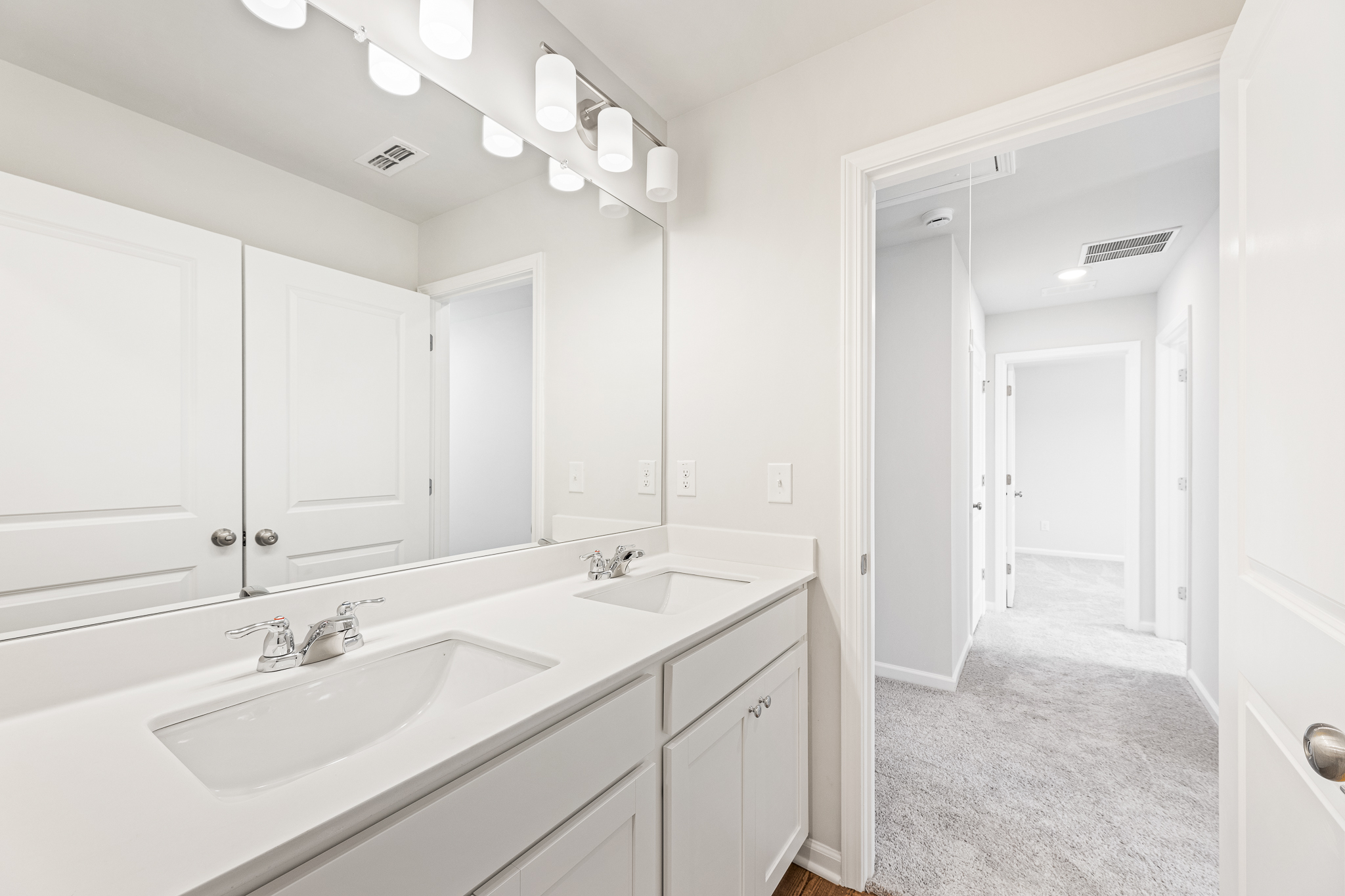 A bathroom with white cabinets.