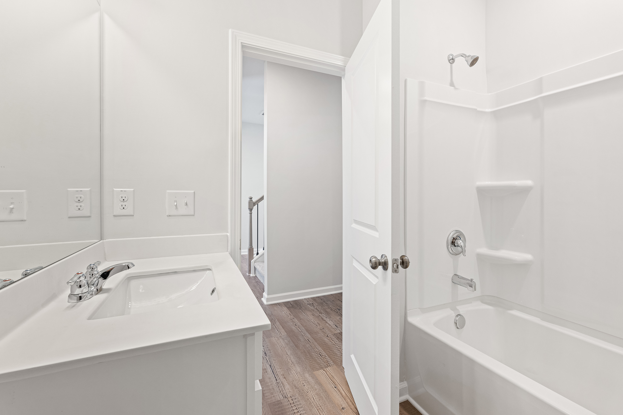 A bathroom with a tub sink and a shower.