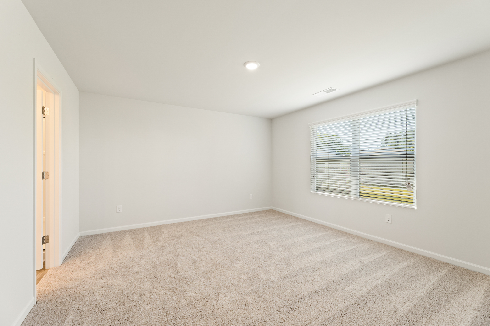A room with a carpet and a window.