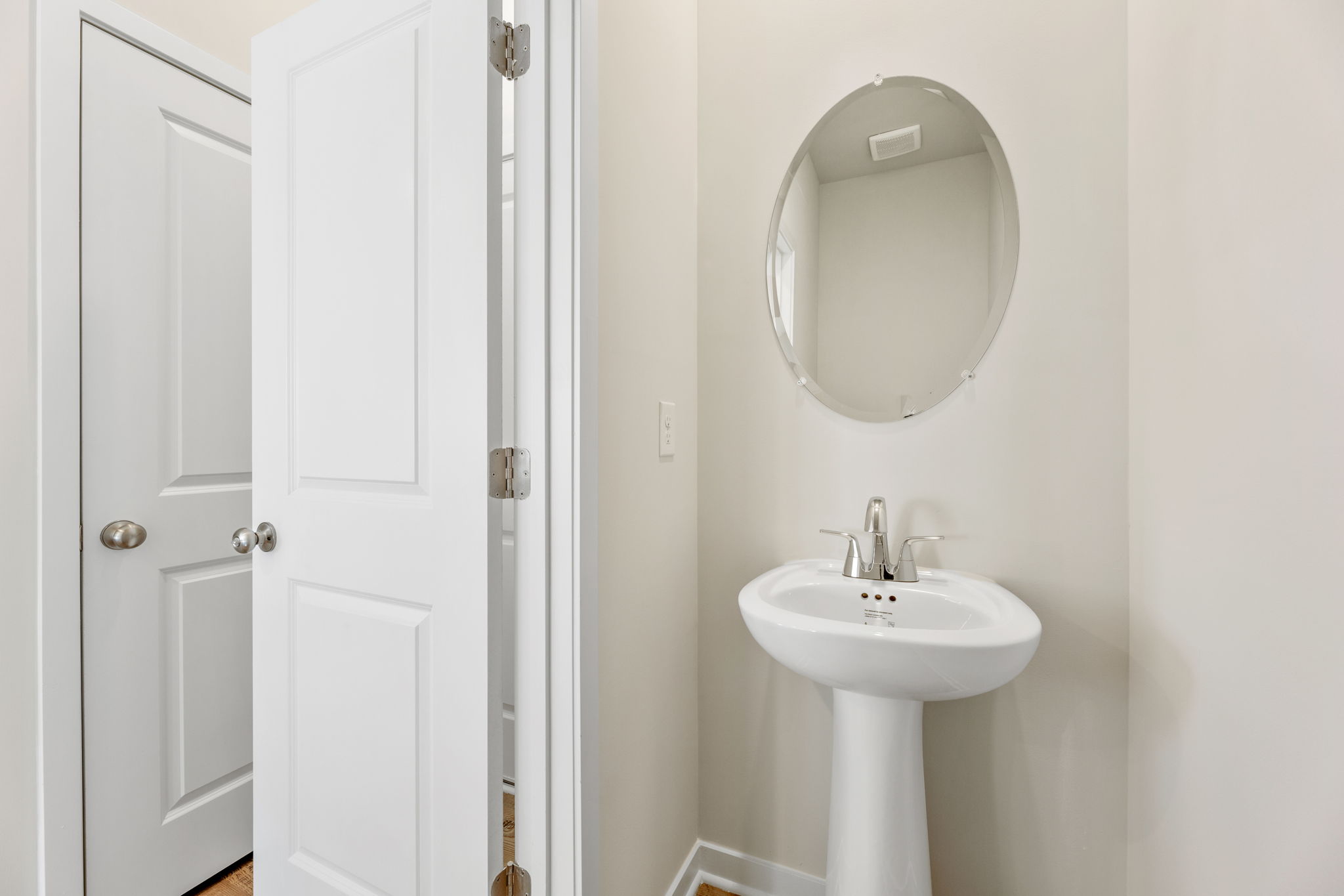 A bathroom with a round mirror.