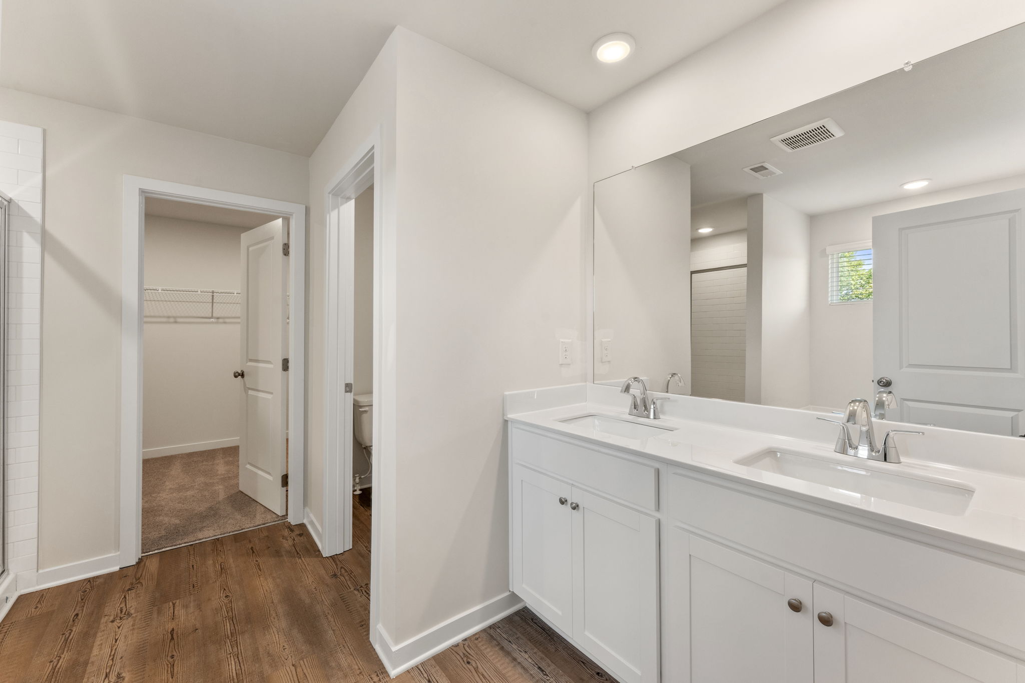 A bathroom with white cabinets.