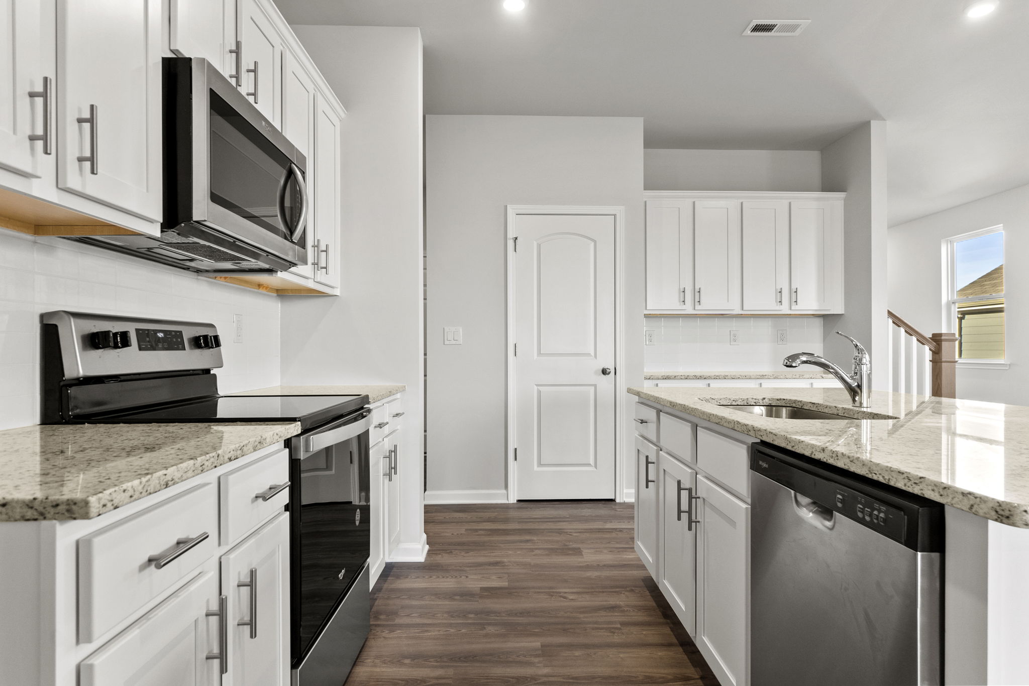 A kitchen with white cabinets.