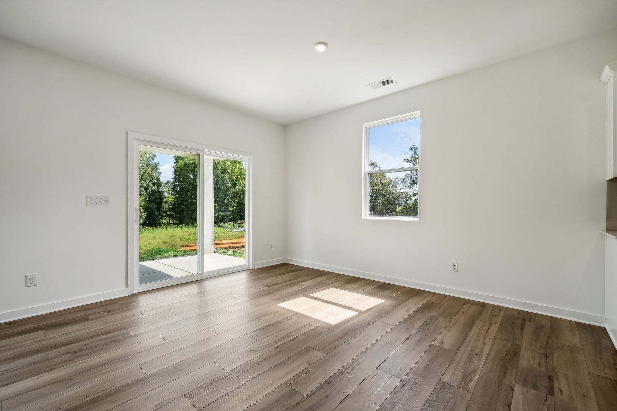 A room with a wood floor and windows.