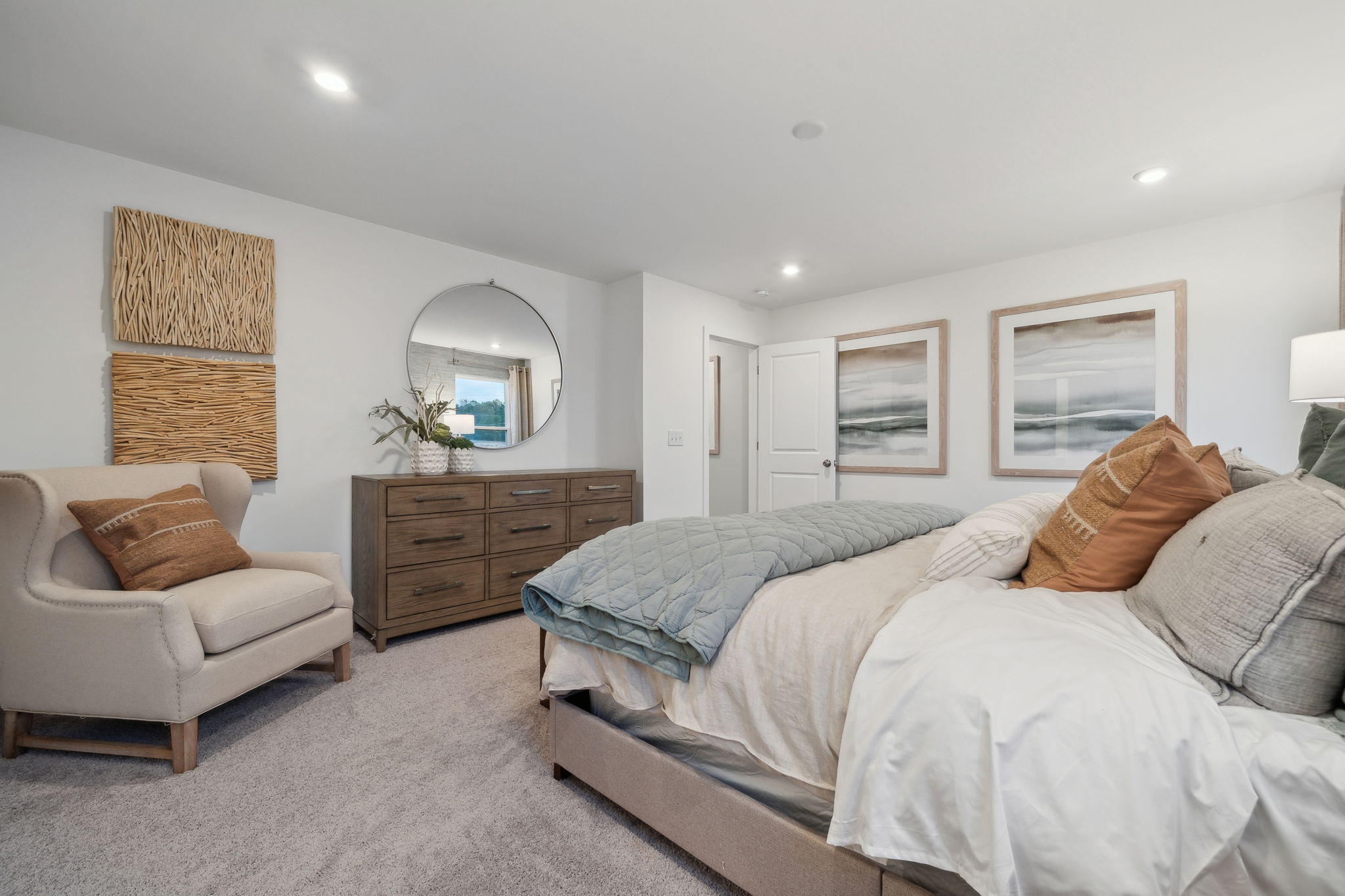 A bedroom with a bed and a chair.