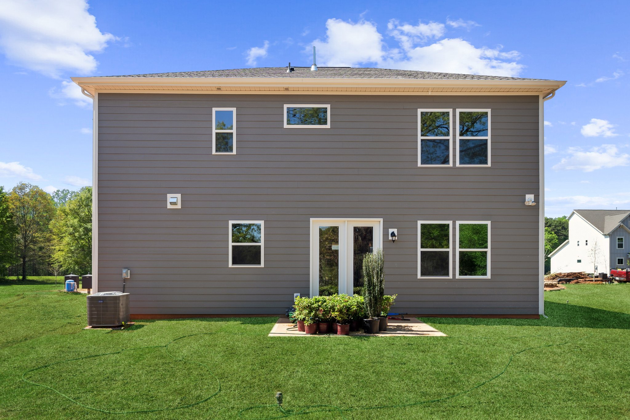 A house with a grass yard with James K. Polk Ancestral Home in the background.