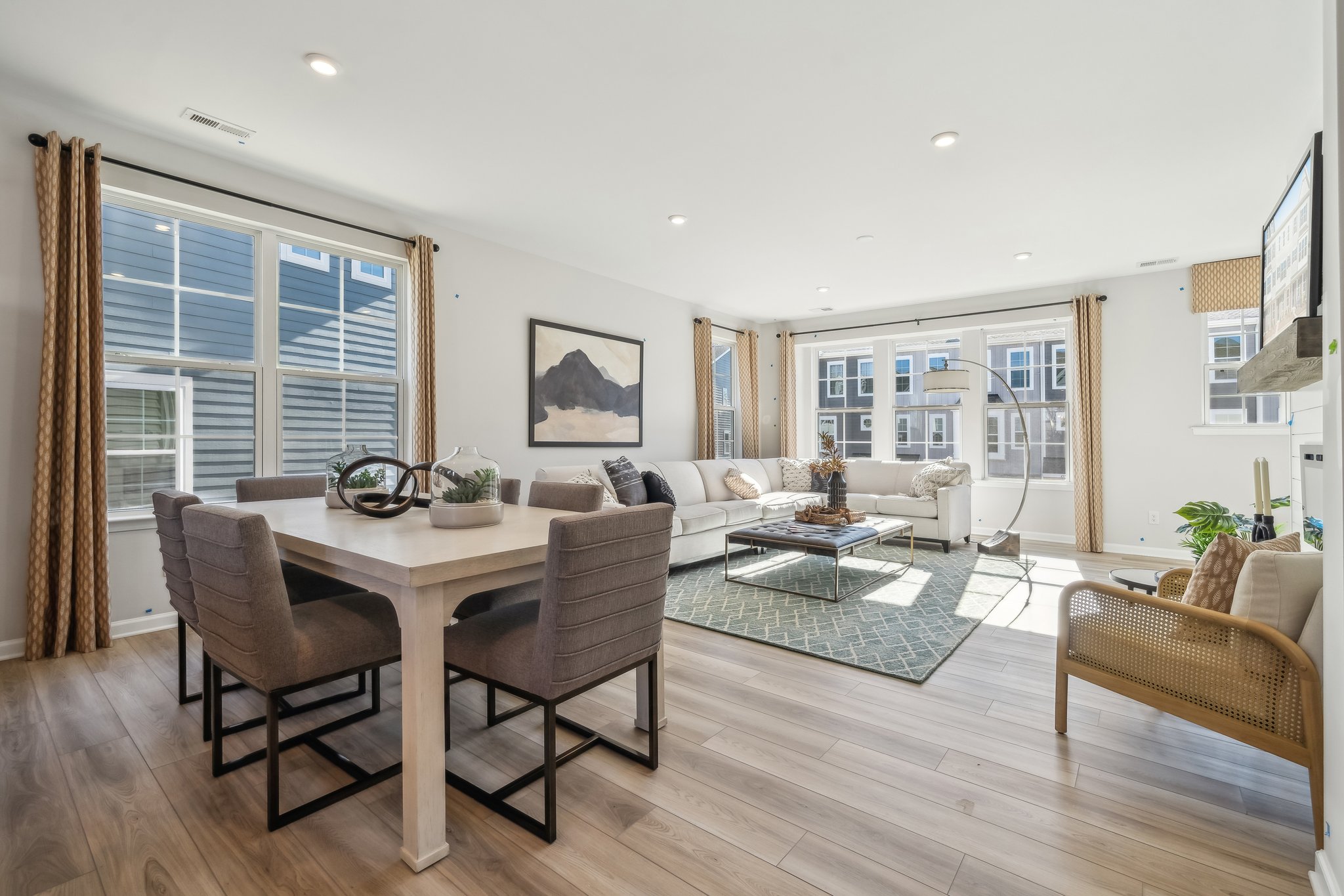 A large living room with a large dining table and a large window.