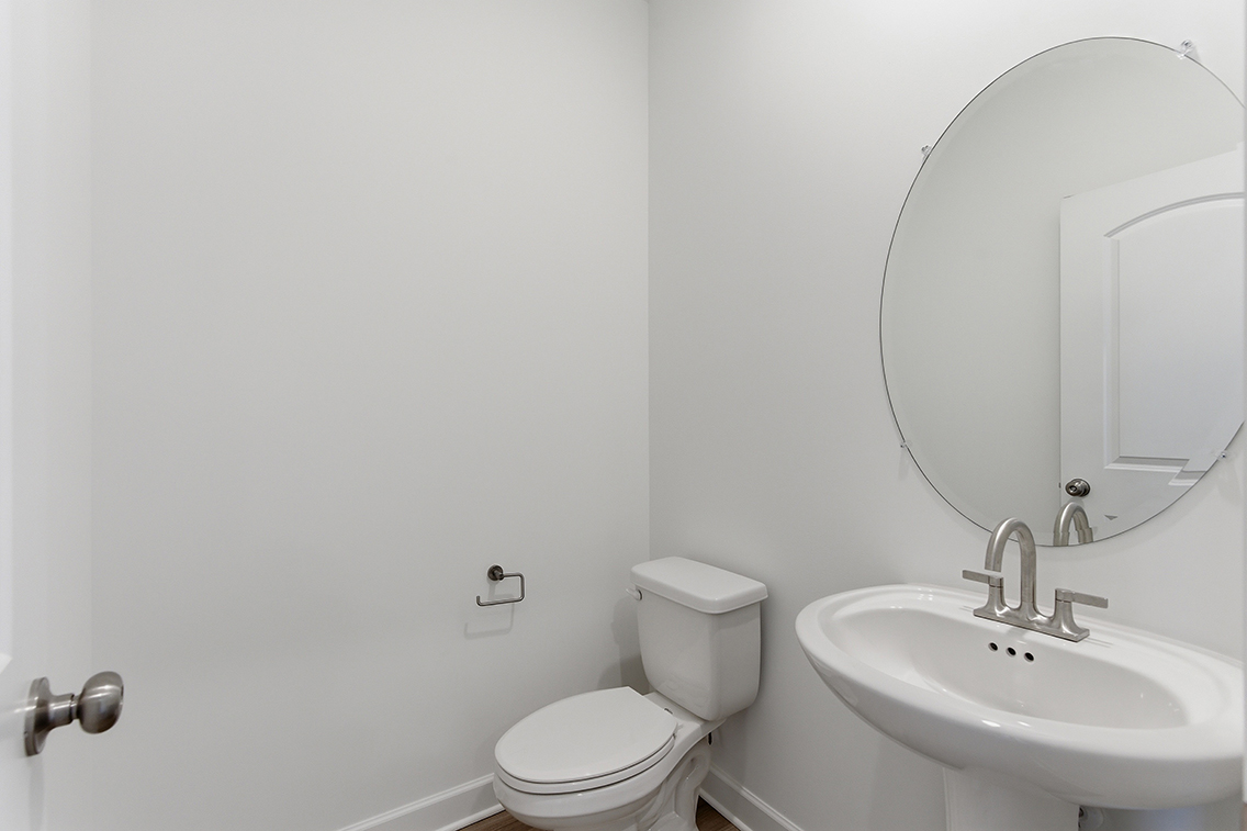 A bathroom with a round mirror.