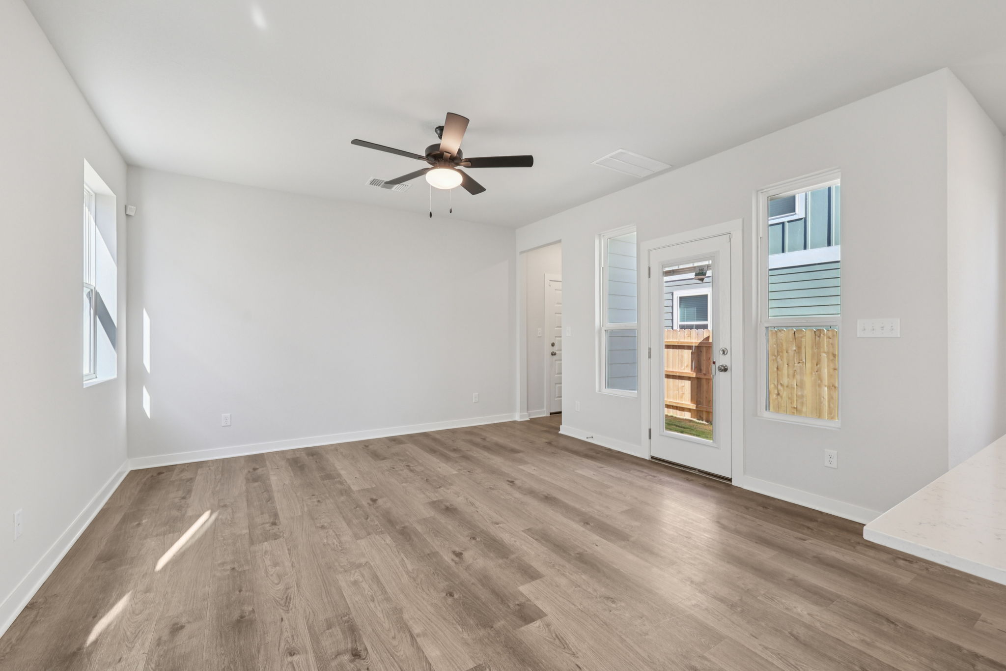 A room with a wood floor and a ceiling fan.