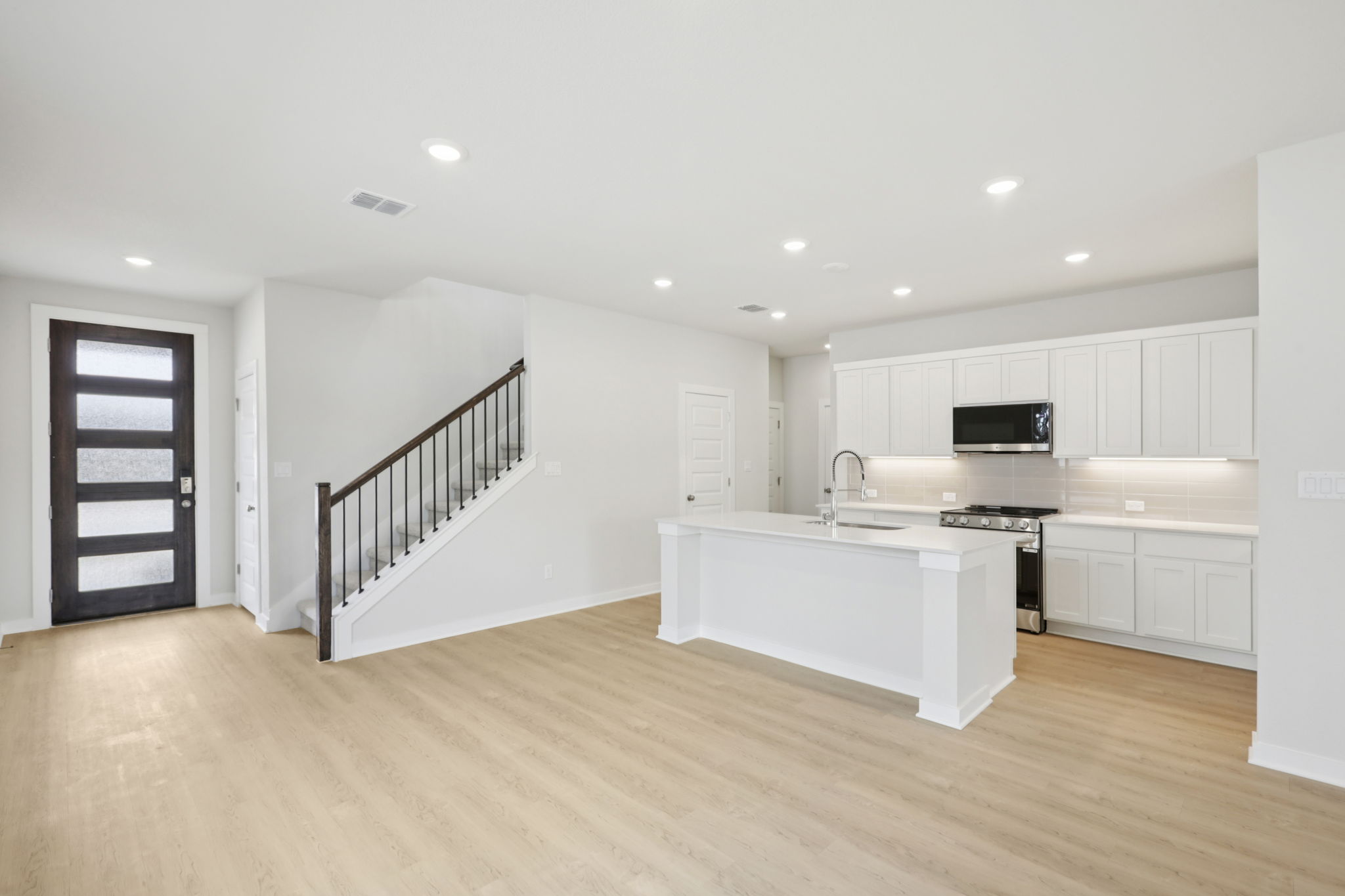 A kitchen with white cabinets.
