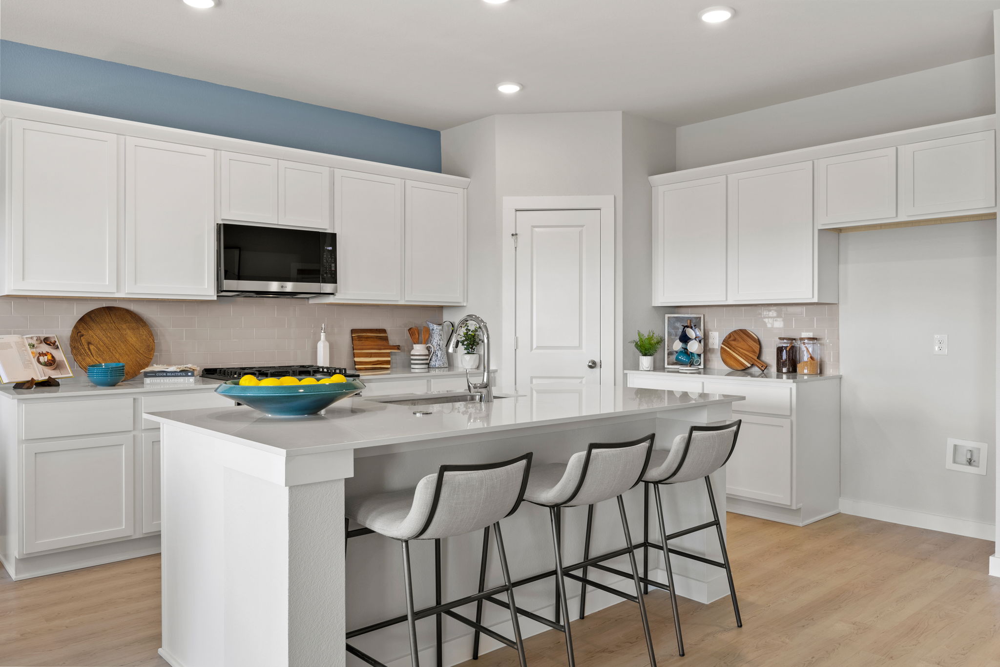 A kitchen with white cabinets.