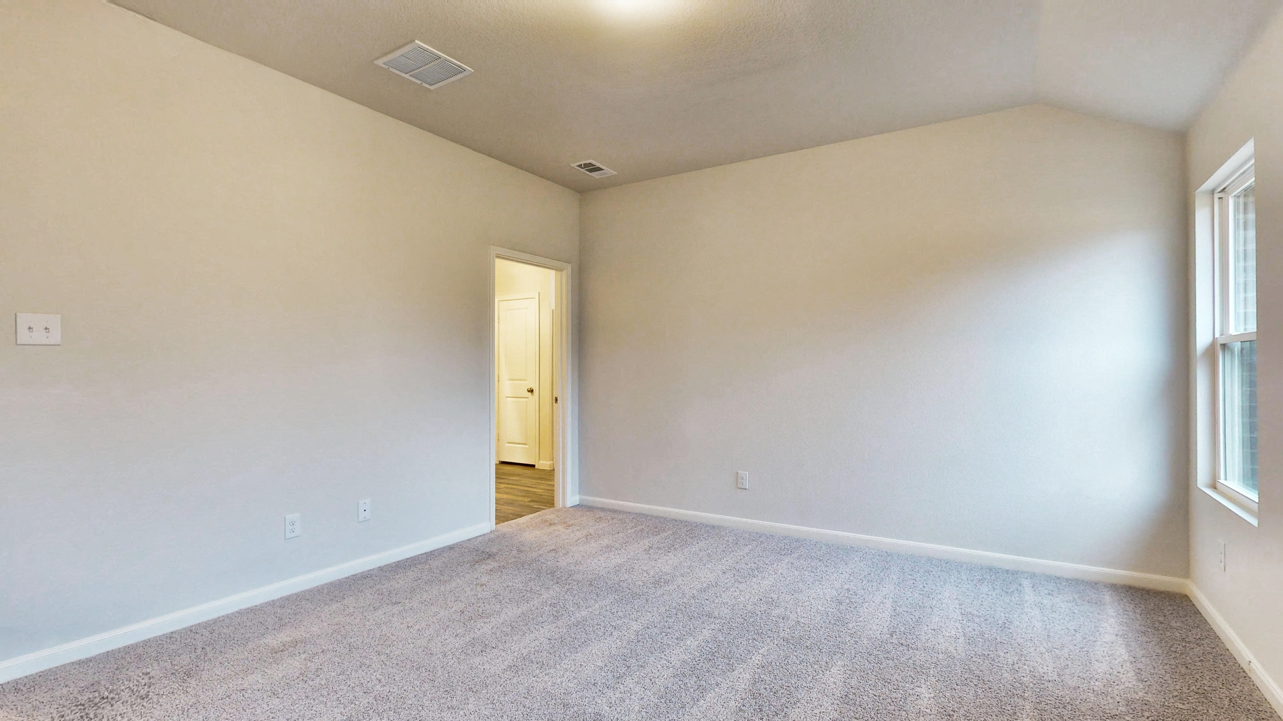 A room with a carpet and a door.