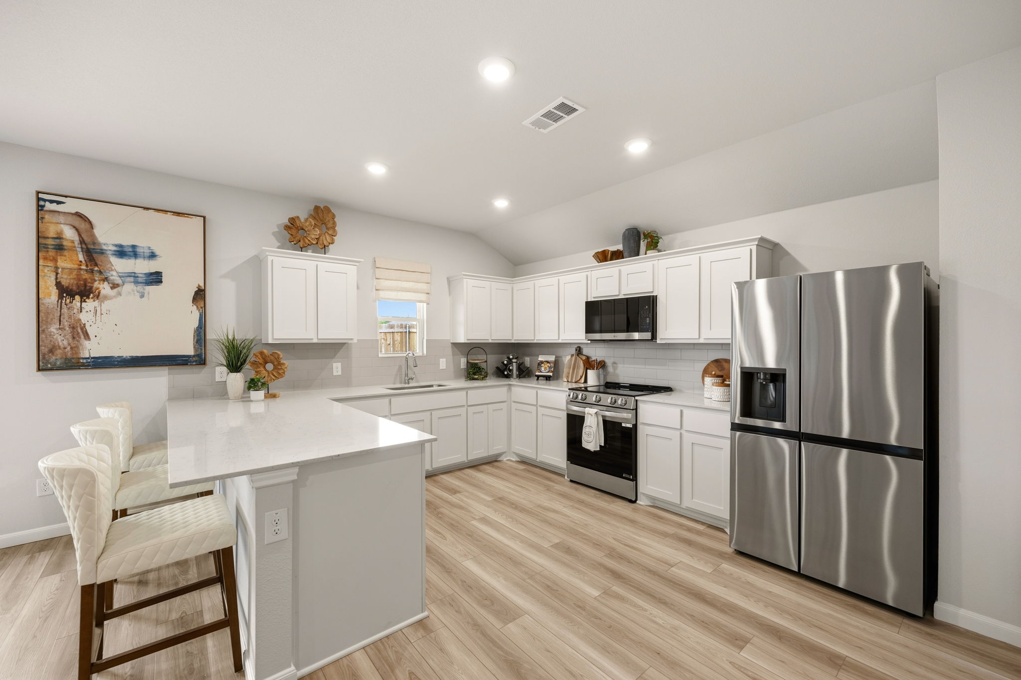 A kitchen with white cabinets.