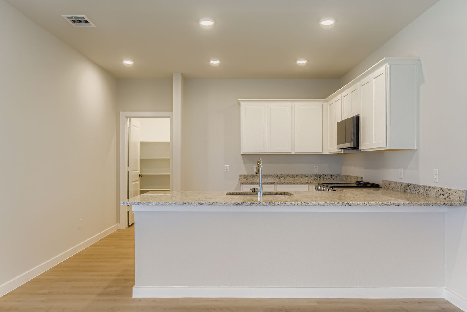 A kitchen with white cabinets.