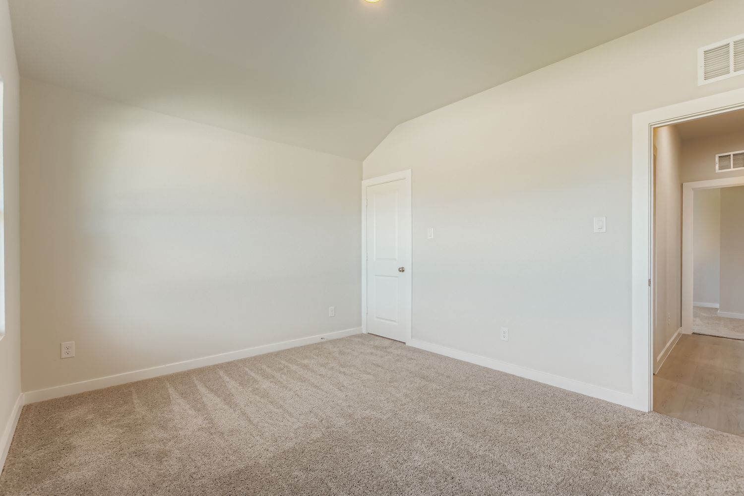 A room with carpet and a door.