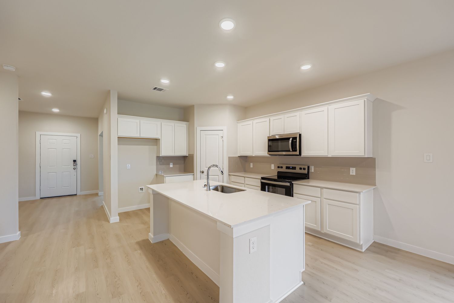 A kitchen with white cabinets.