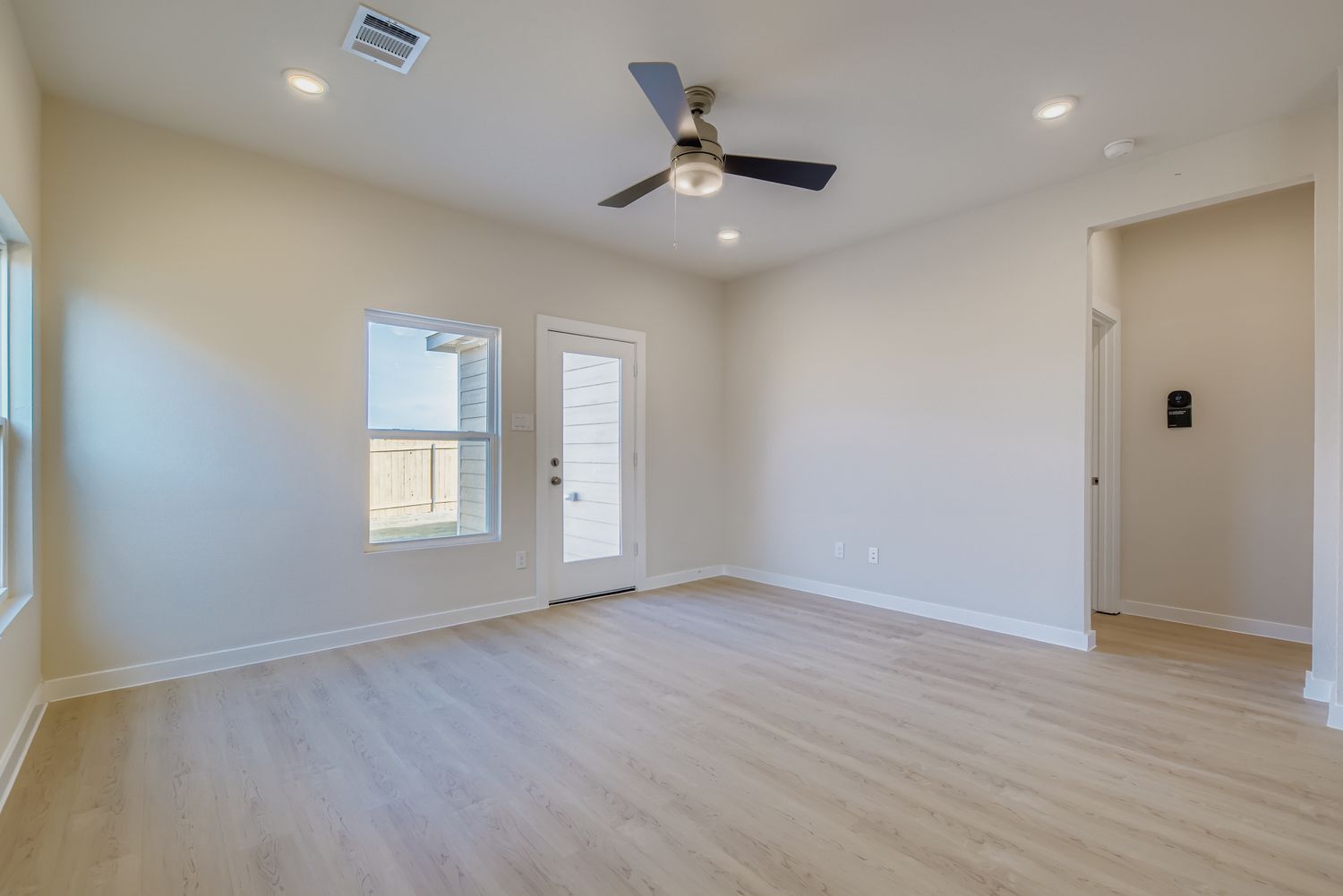 A room with a wood floor and a ceiling fan.