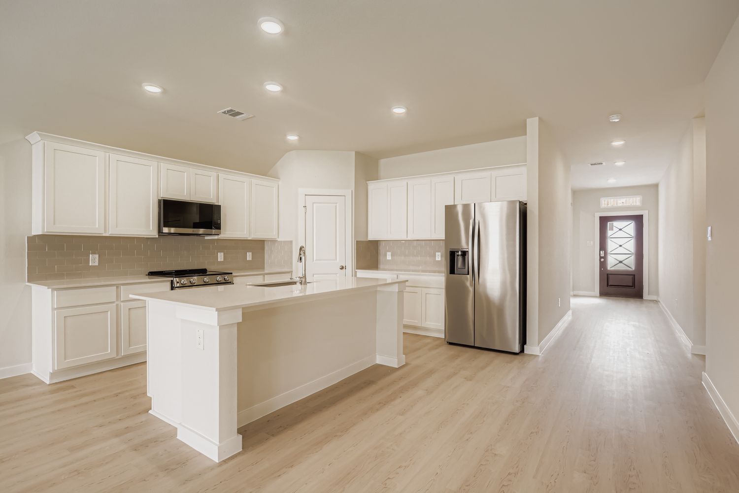 A kitchen with white cabinets.