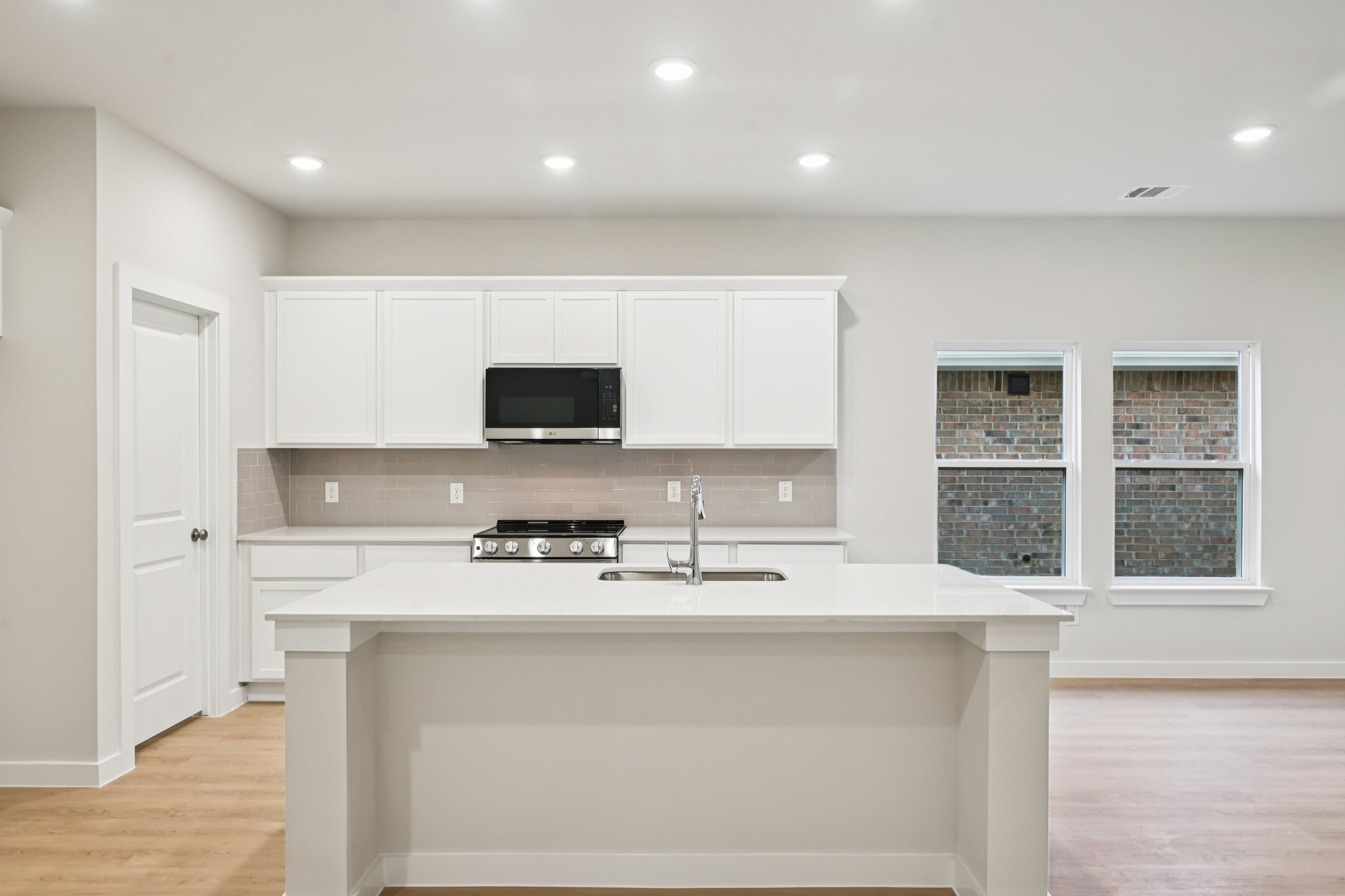 A kitchen with white cabinets.
